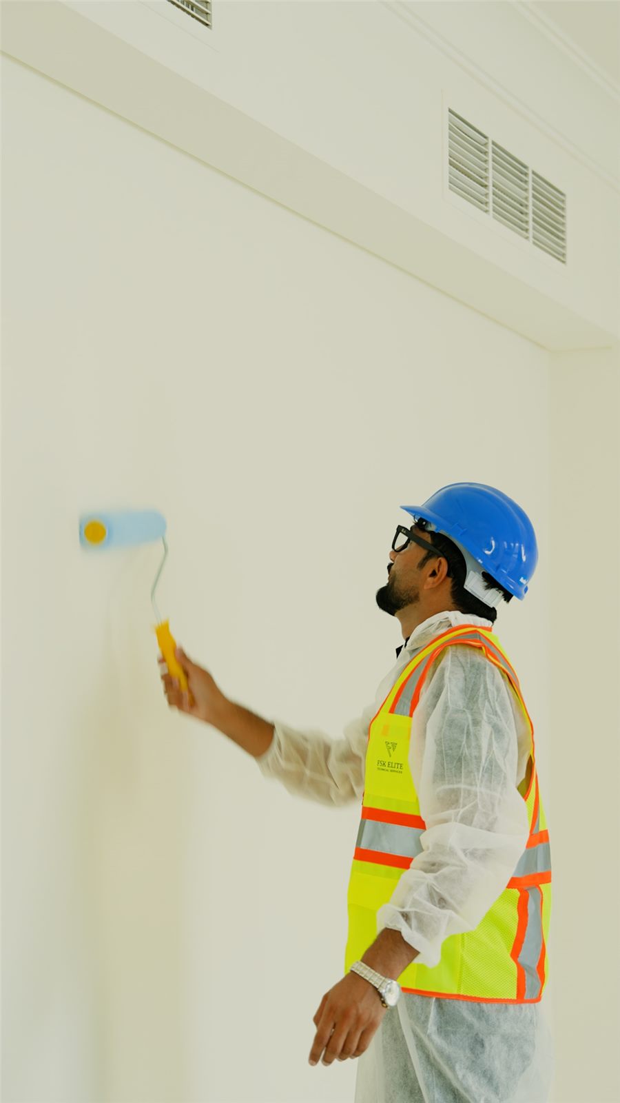 FSK Elite technician painting an interior wall in Dubai